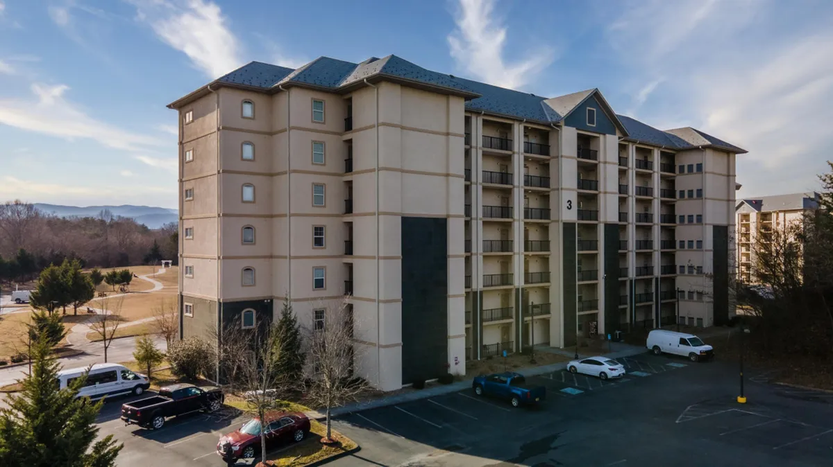 This exterior image showcases the welcoming facade of Sweet Drake, surrounded by lush greenery and a spacious parking area. The setting is tranquil, inviting, and hints at the accessibility of the building for guests of all ages.